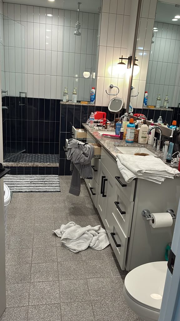 Bathroom before PureGlow cleaning, towels and products out of place