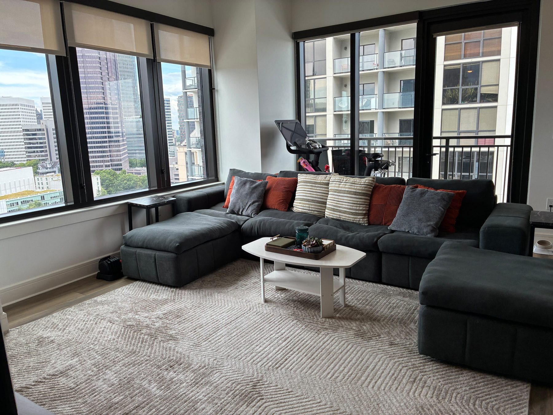 A tidy, sunlit living room in an Atlanta high-rise apartment cleaned by PureGlow